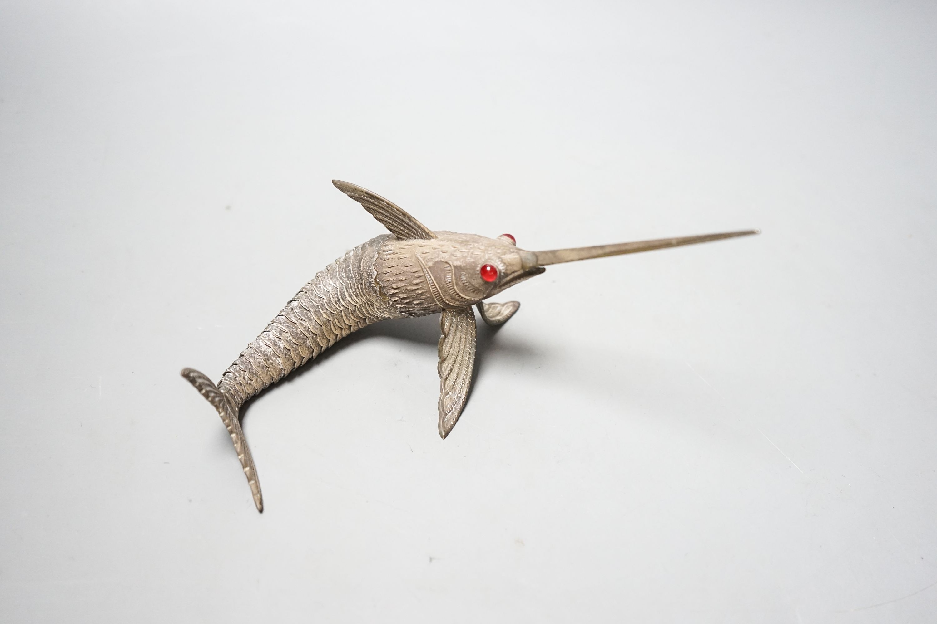 A 20th century Spanish articulated white metal model of a swordfish, with red glass eyes, approx. 26.5cm, gross weight 118 grams.